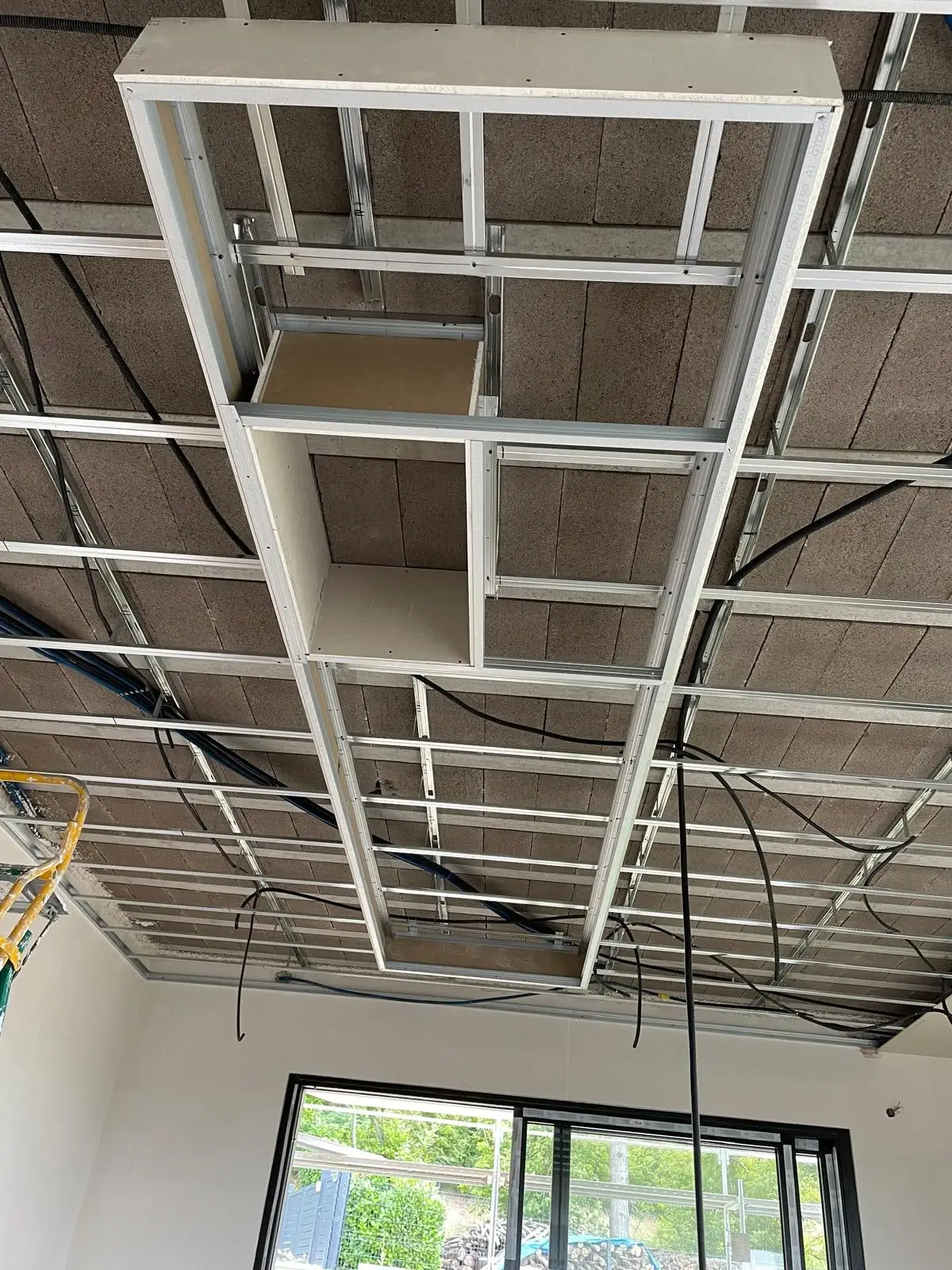 Ossature métallique d’un faux plafond avec retombée technique et coffre
